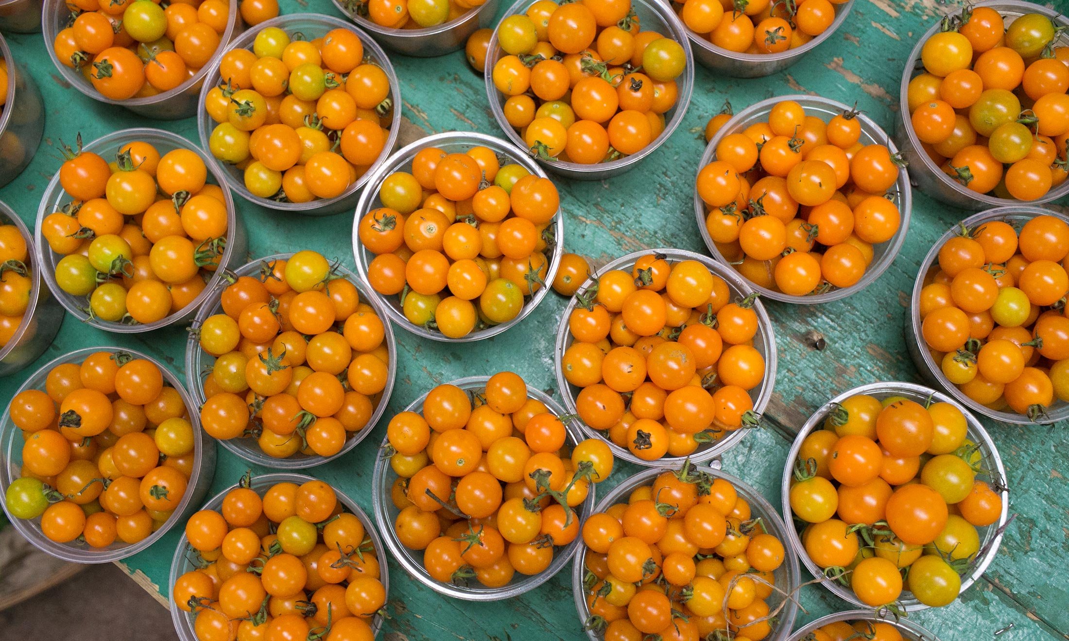 Yellow cherry tomatoes in bowls available for purchase at the Royal Oak Farmers Market