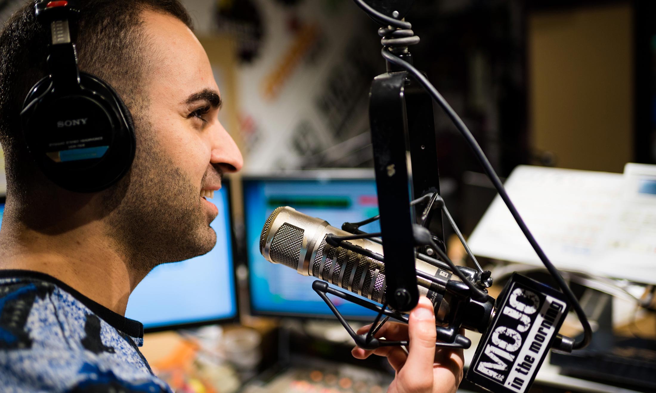 Joe Namou listens for sound with his headphones in the iHeartRadio studio 