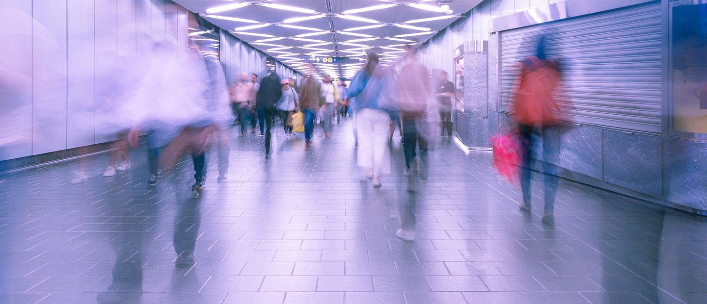 blurred people walking through a subway station