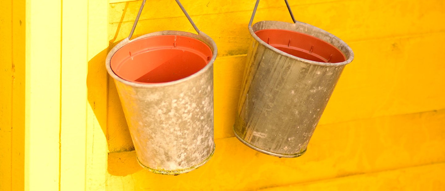  two buckets hanging on a yellow wall