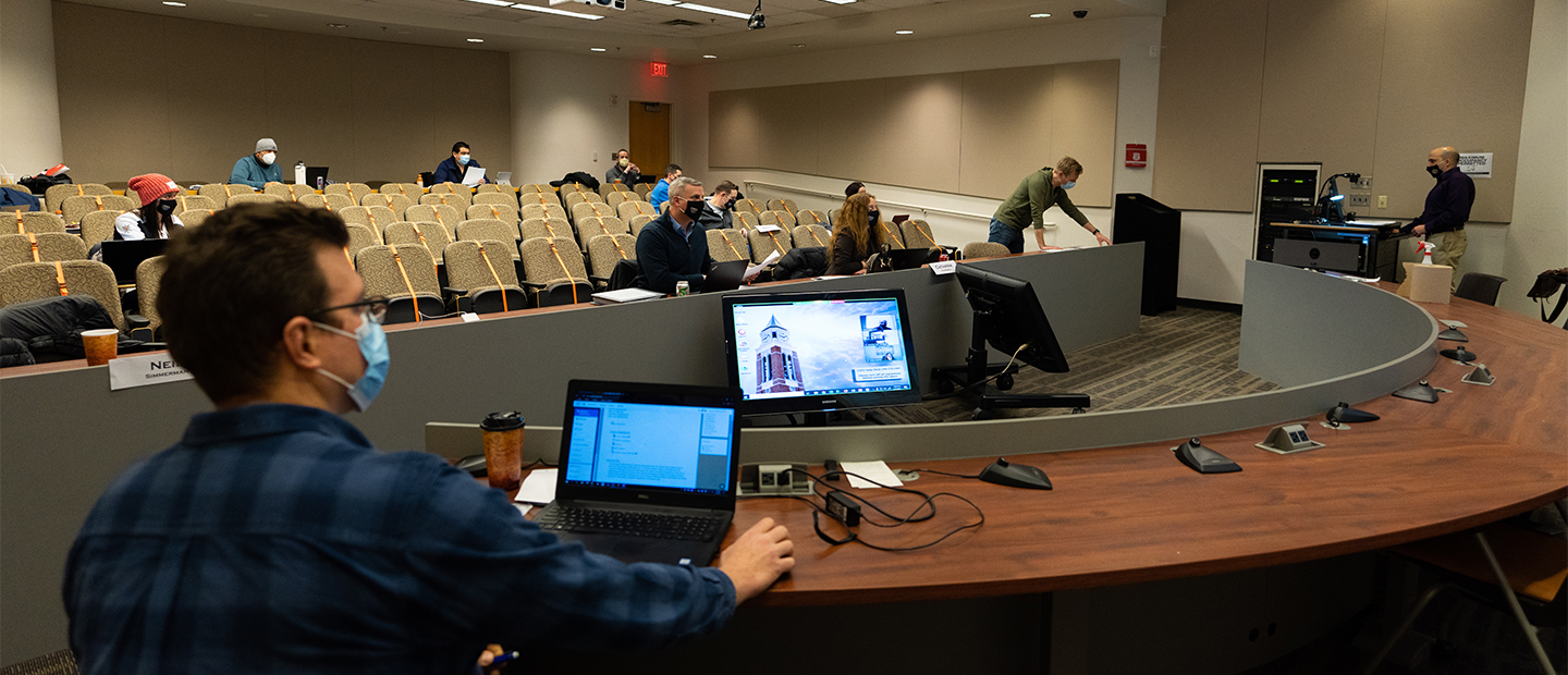 A man using computer equipment for a lecture
