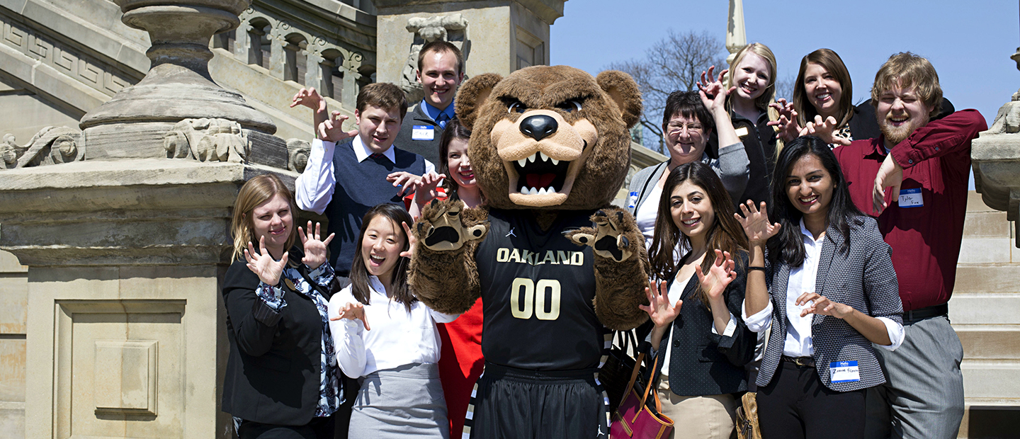 A group of students posing for a photo with the Grizz bear mascot.
