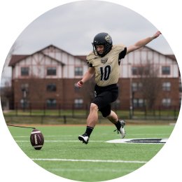 man running up to kick a football