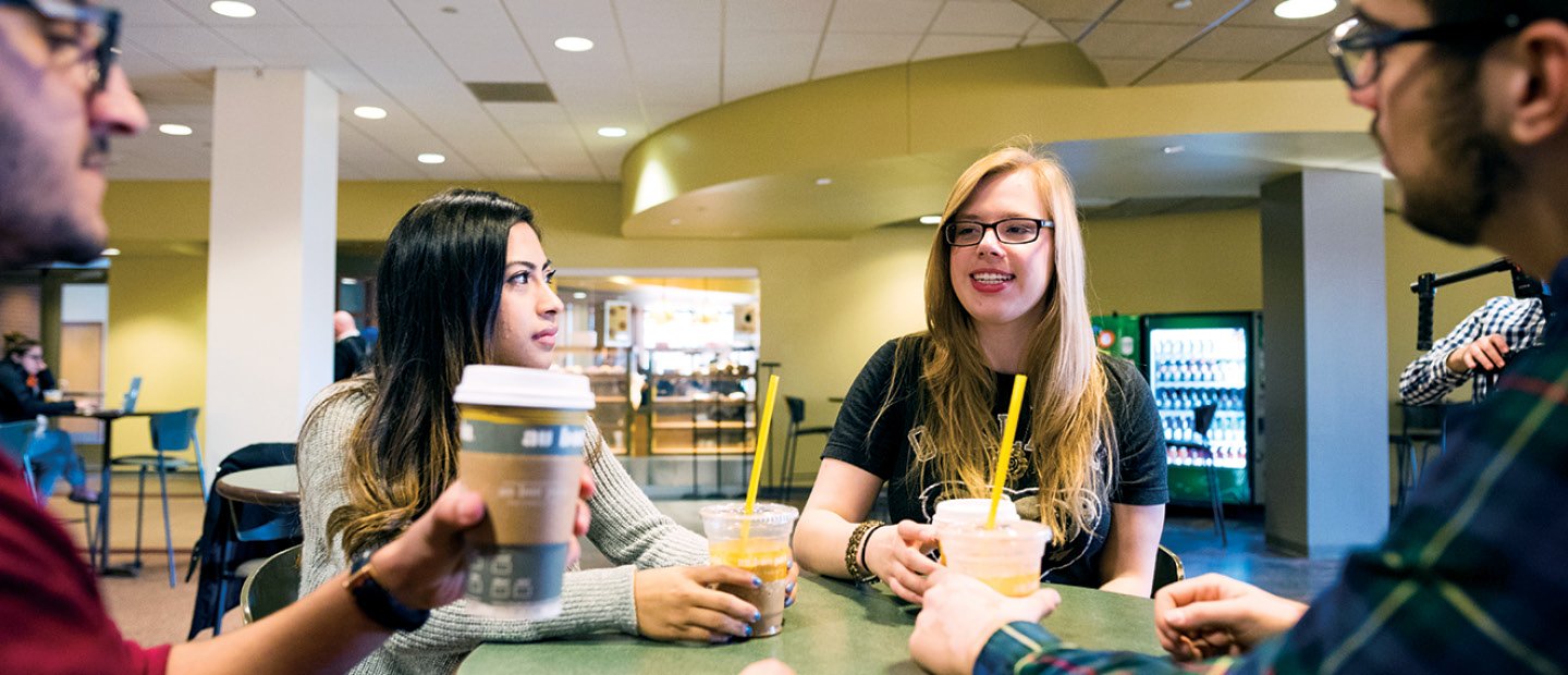 Students seated at a table with au bon pain cafe drinks