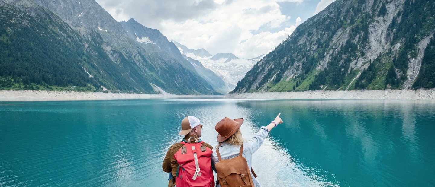 Two people on a lake in the mountains.