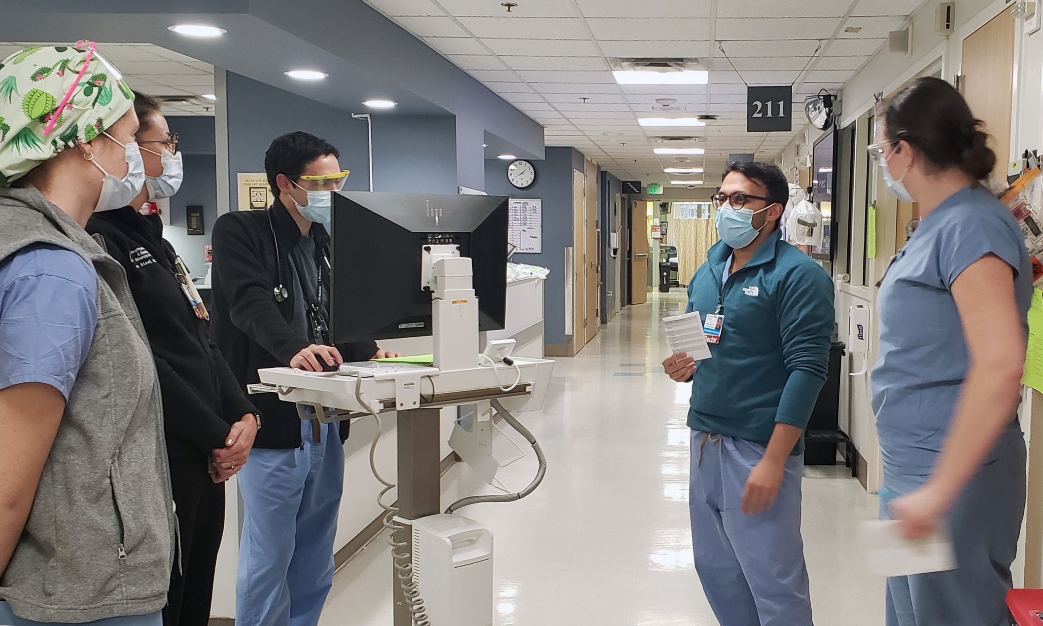 An image of Jay Brahmbhatt, M.D. talking to residents in a hospital setting