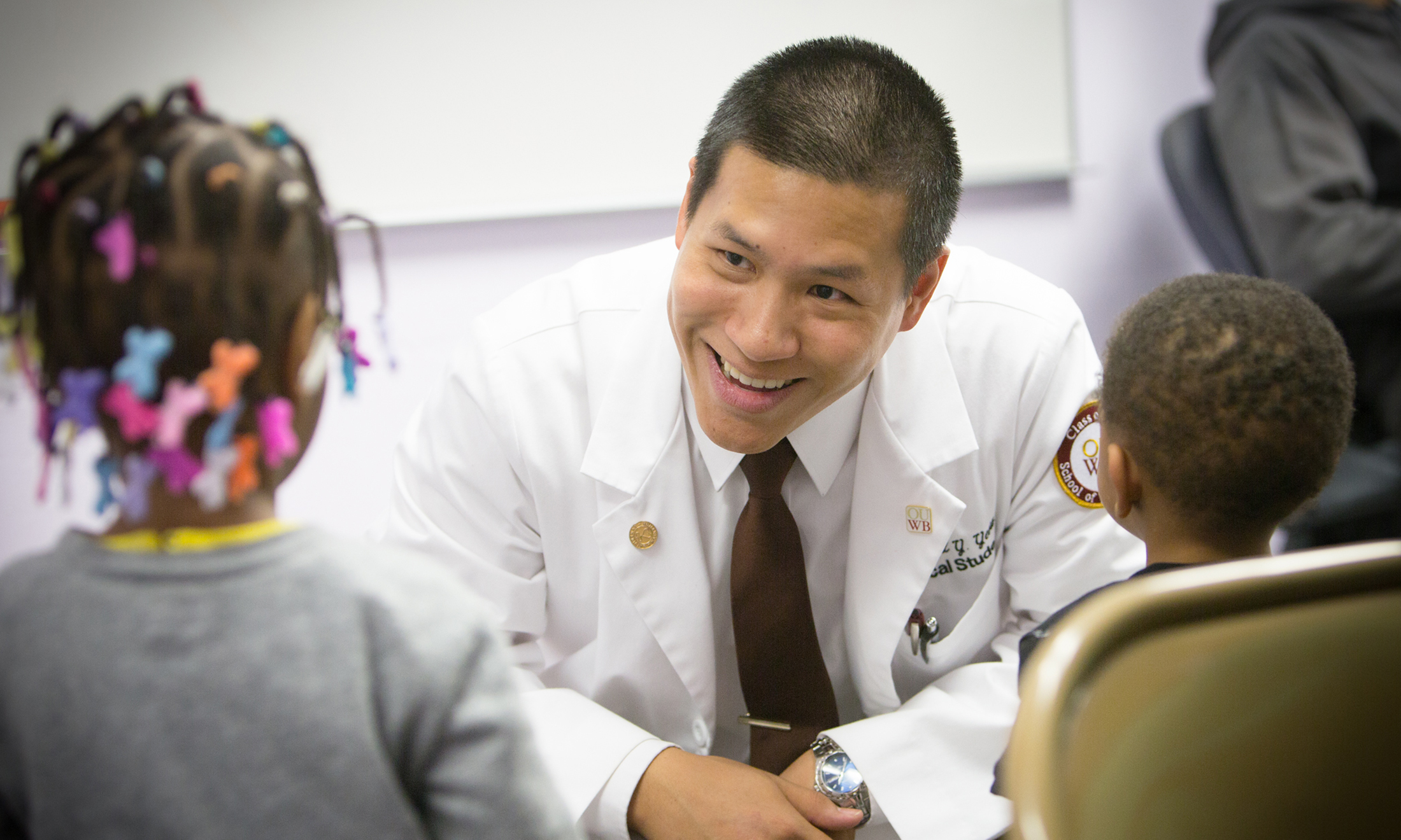 An image of Raymond Yeow, M.D., talking with children.