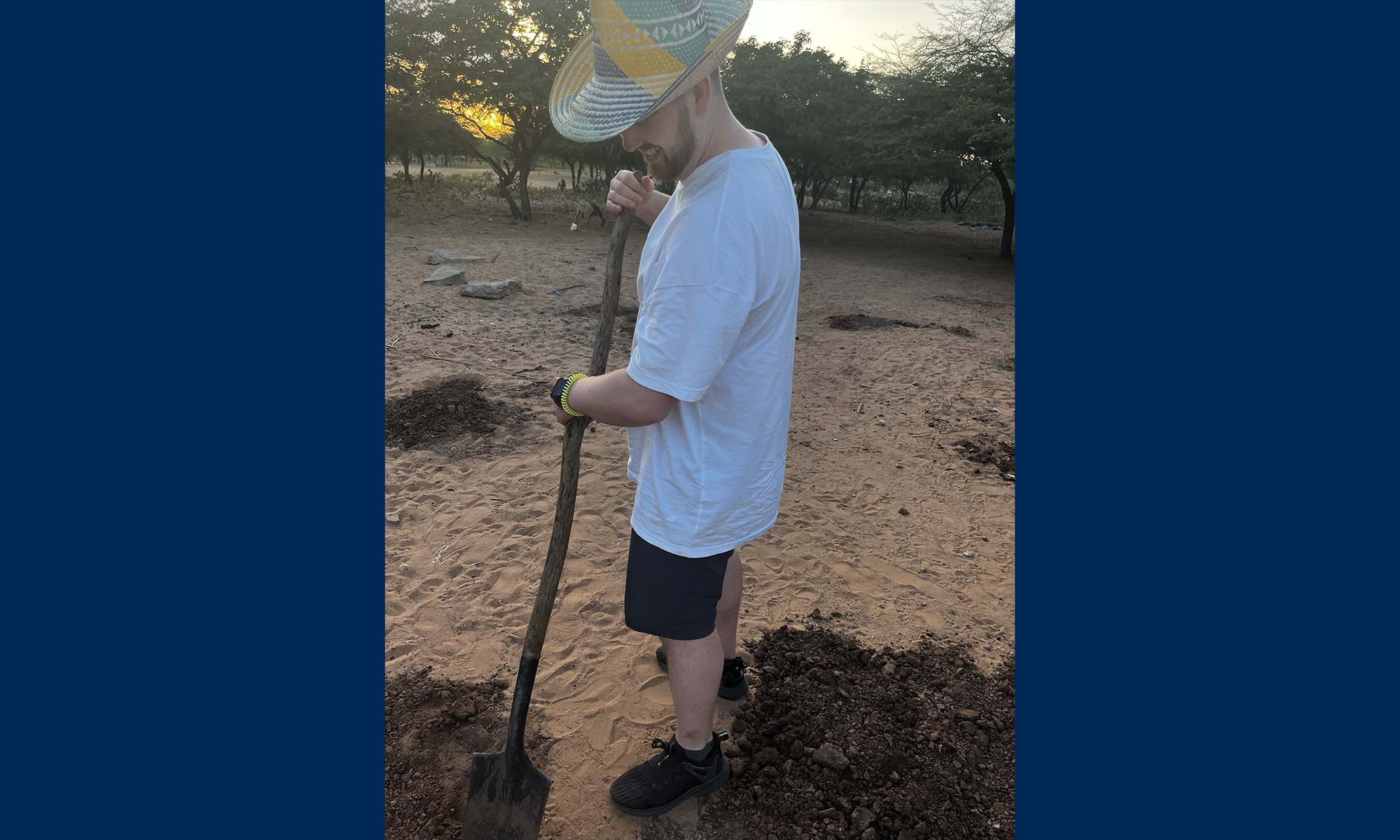 An image of Quinn Simpson digging a post hole