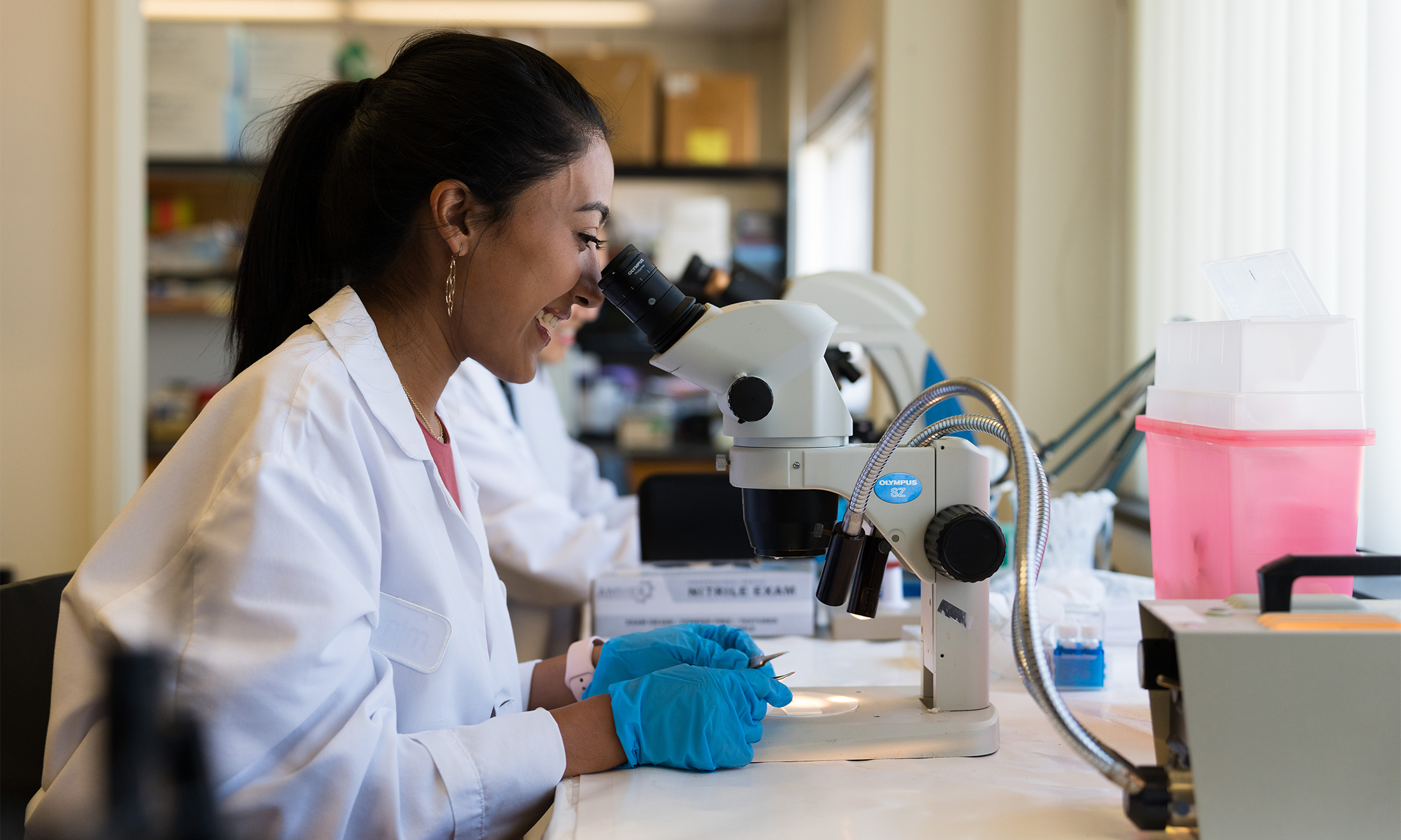 An image of Suhani Gupta using a microscope