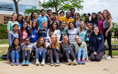 Alison Thomas posing in a group photo with students at a summer camp