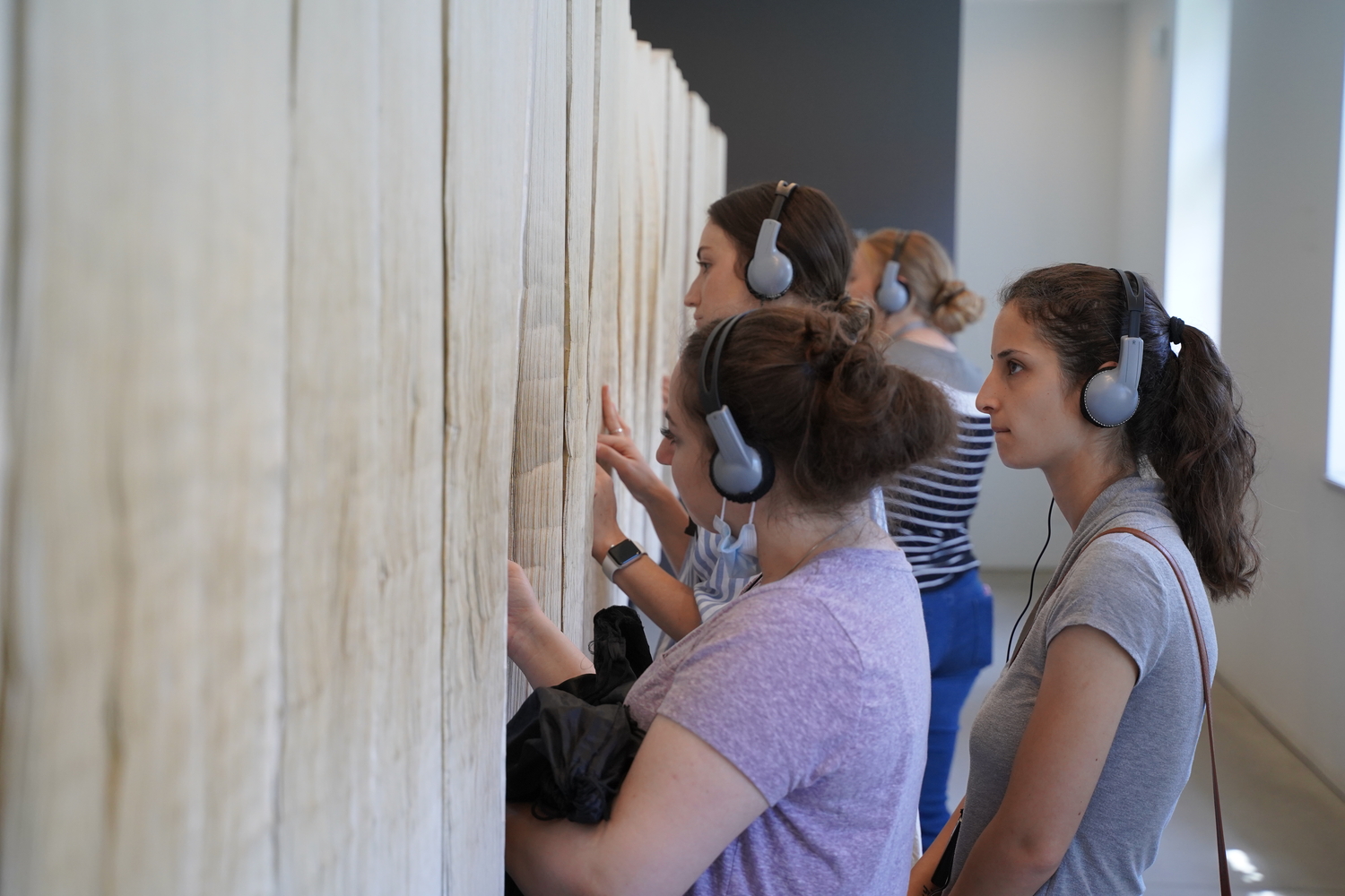 A group of students looks at the Book of Names exhibit