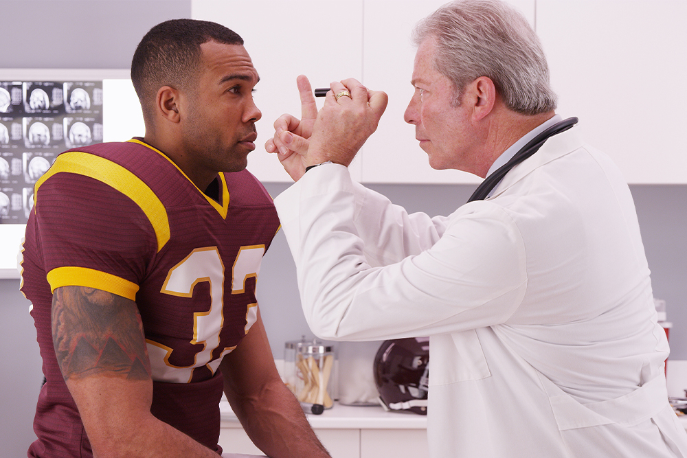 An image of a football player being examined by a physician