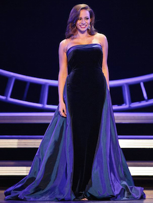 Erica Kennedy wearing a dark-colored evening gown on a stage