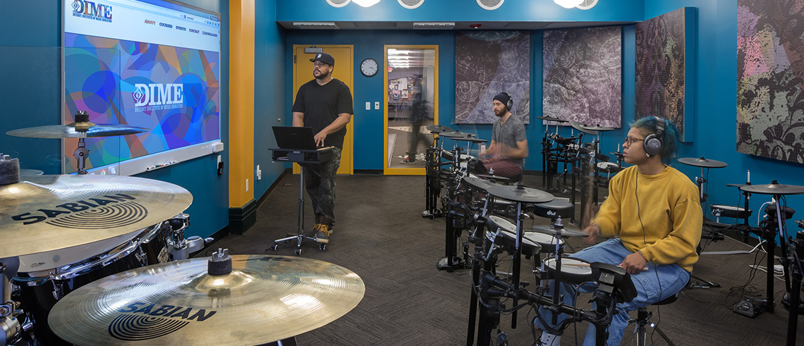 Students in a classroom with drum sets.