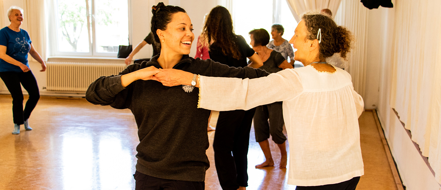 image of two women dancing together, smiling