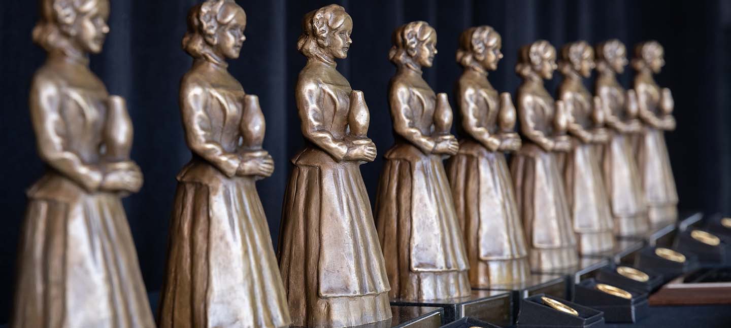 bronze awards shaped like women lined up on a table