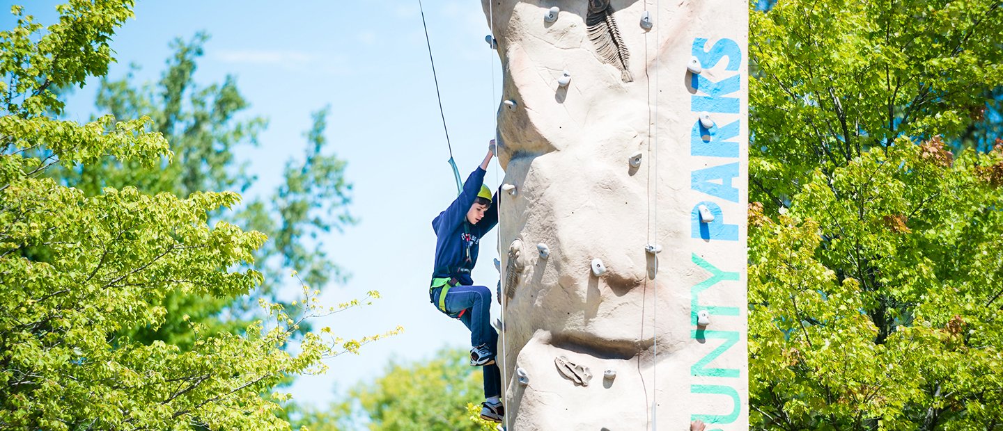 A child climbing a rock wall in a park.