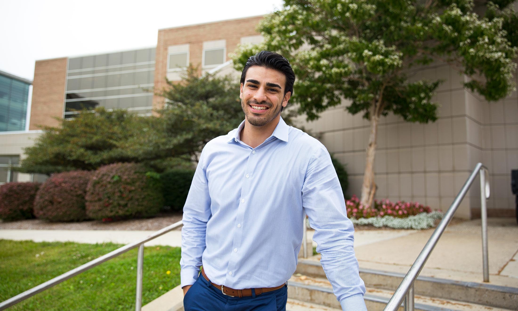 Oakland University Student Congress Vice President Jousef Shkoukani stands on the steps outside of the School of Business Administration building on campus