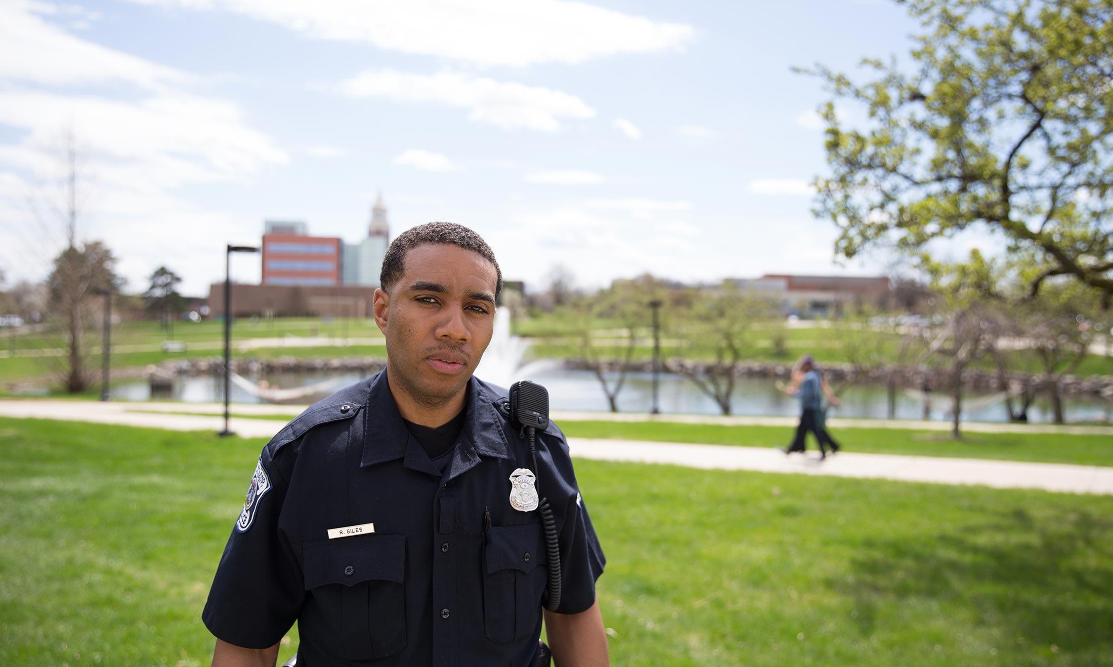 Oakland University Police Department officer Raashan Giles stands outside next to Bear Lake on campus