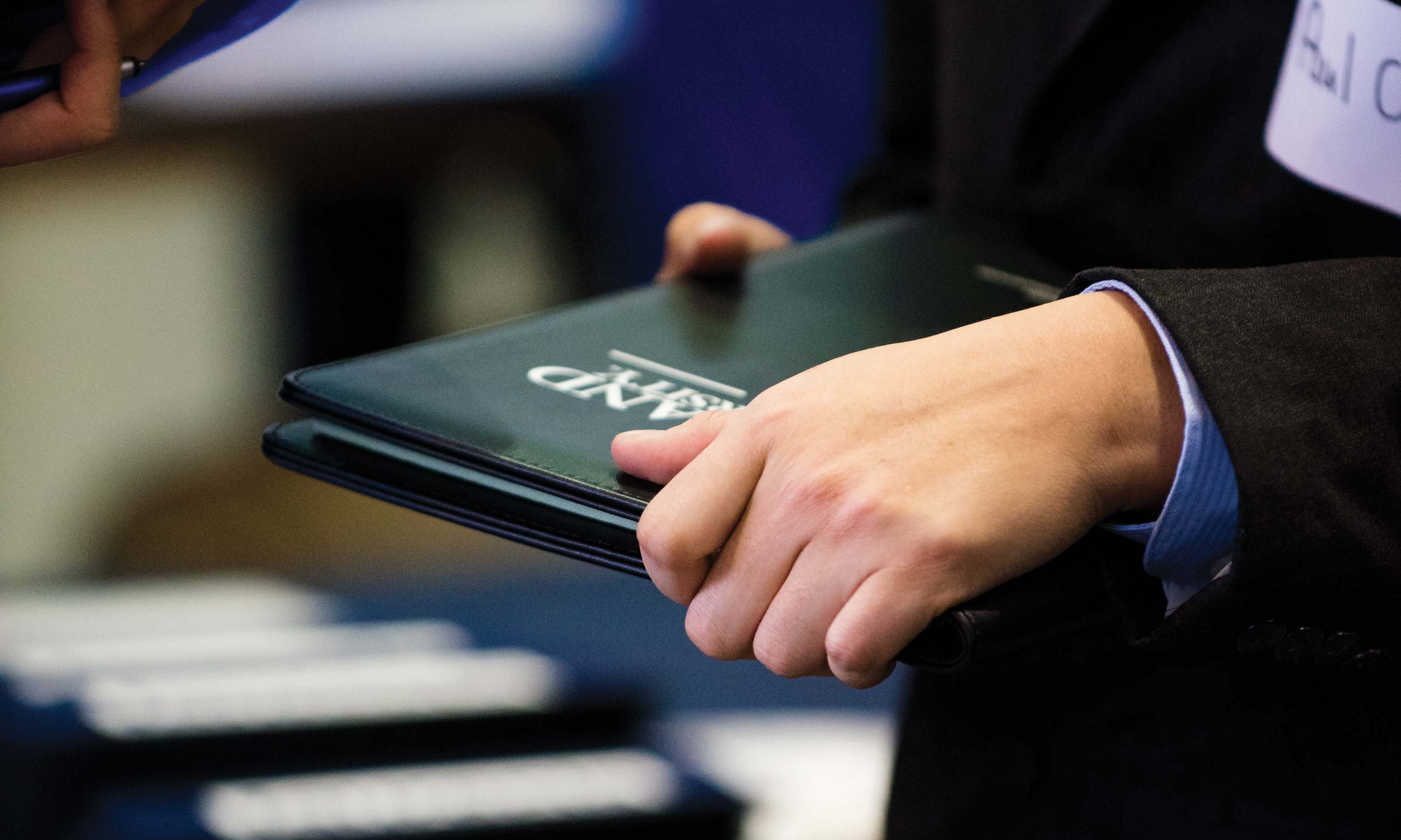 Person holding a black Oakland University portfolio at the Winter Career Fair, hosted by Oakland University's Career Services