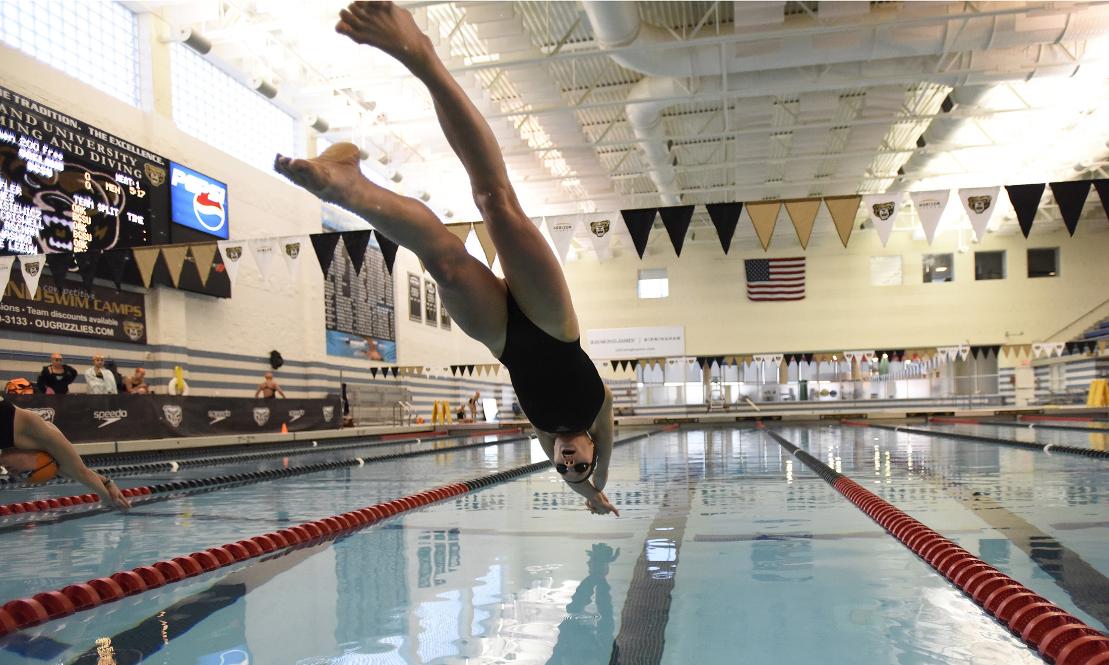 Photo of Oakland University swimmer Patricia Aschan diving into the pool
