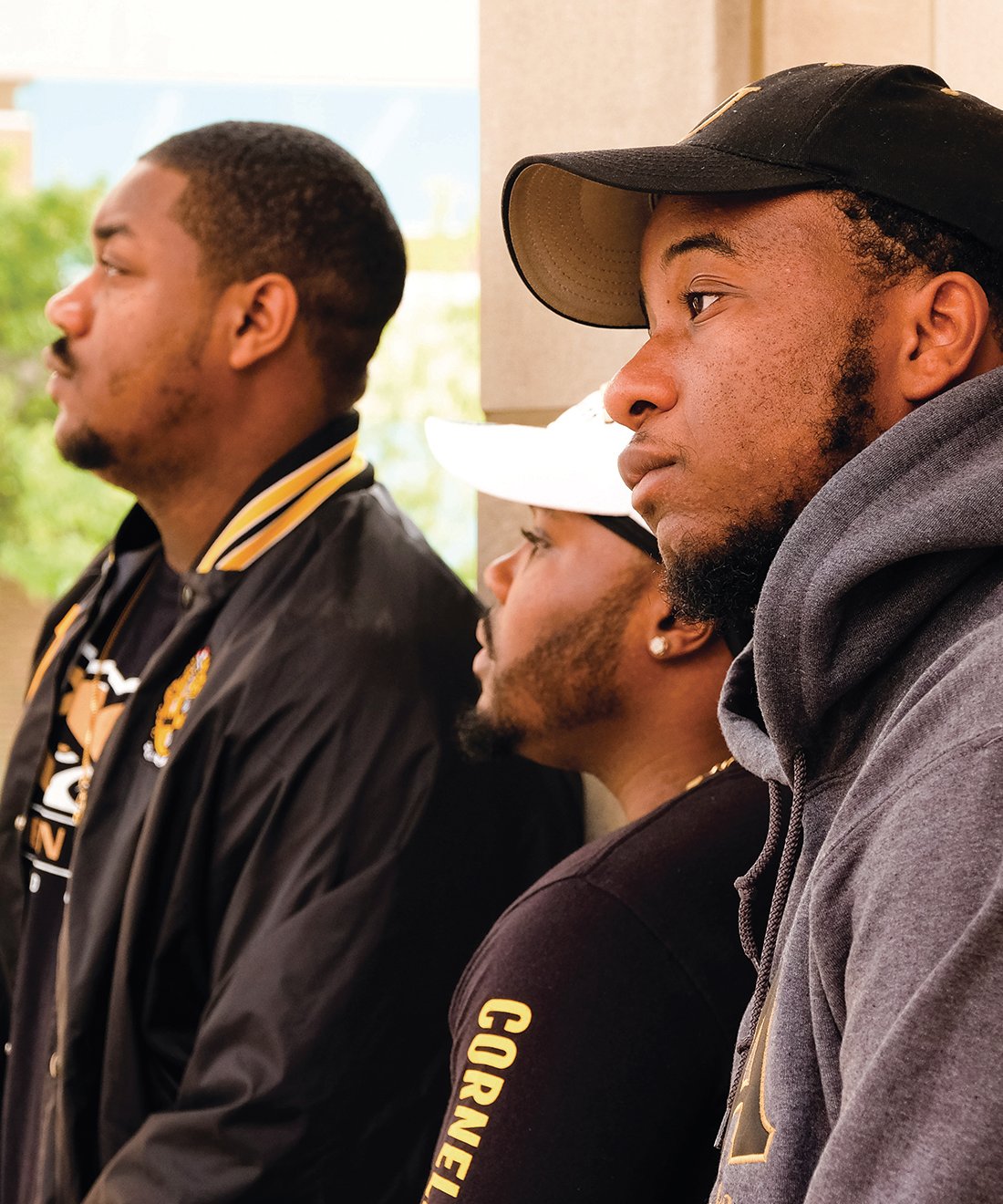 Three members of Alpha Phi Alpha fraternity look into the distance