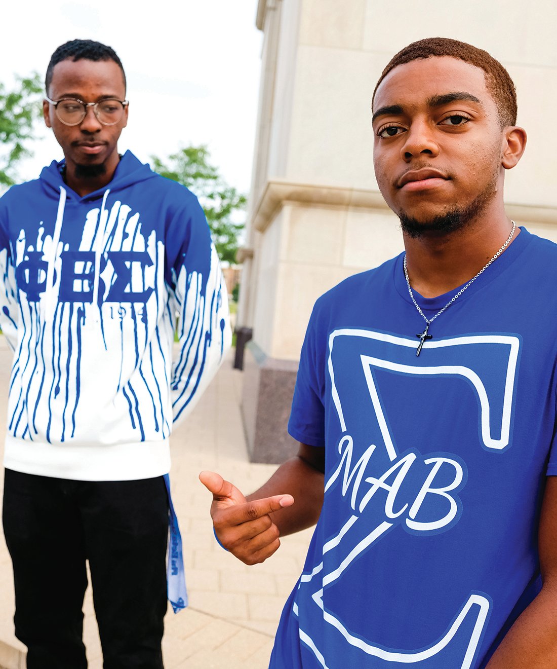 Two members of Phi Beta Sigma, one looking down and one looking directly at the camera