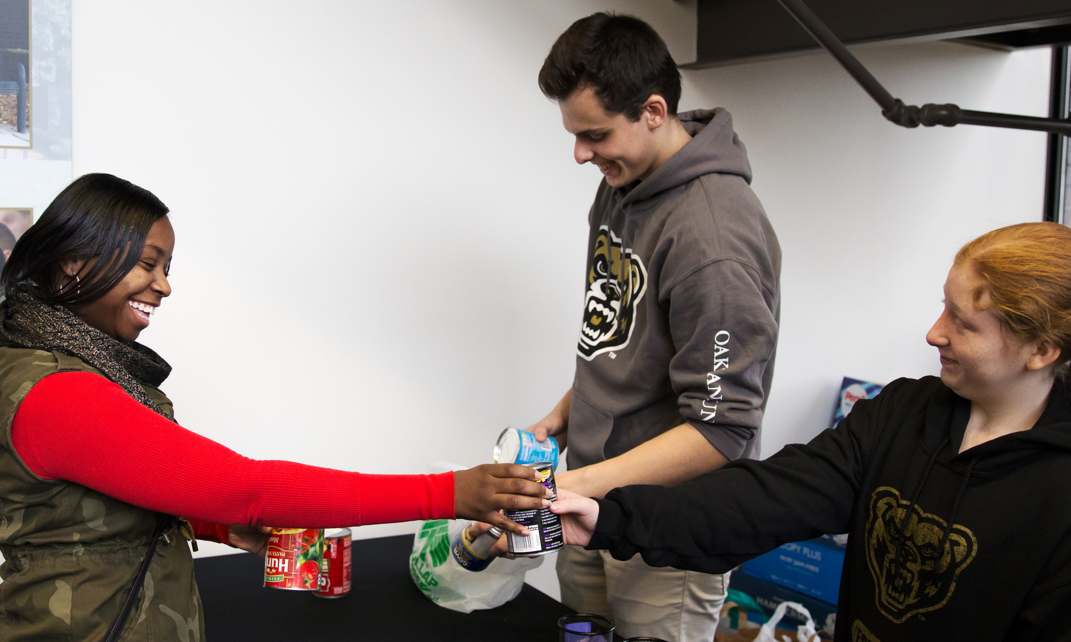 A woman donates a cans of food to Oakland University students at a canned food drive in Macomb