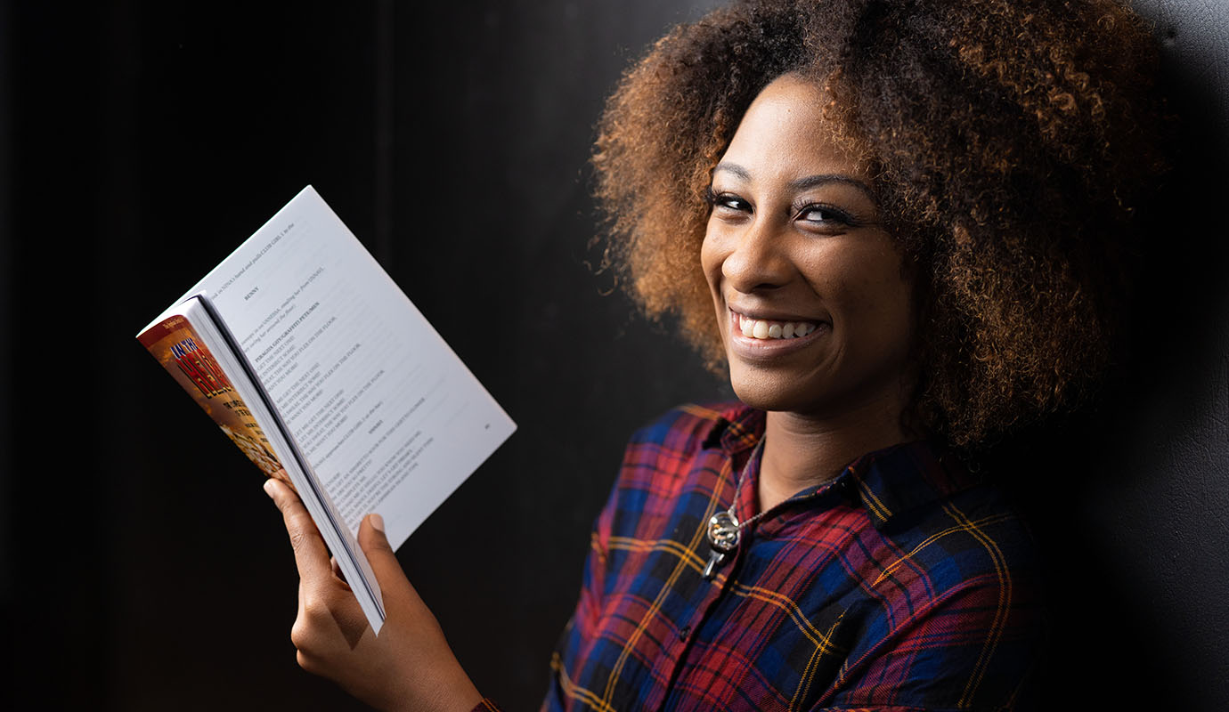Student smiling holding book