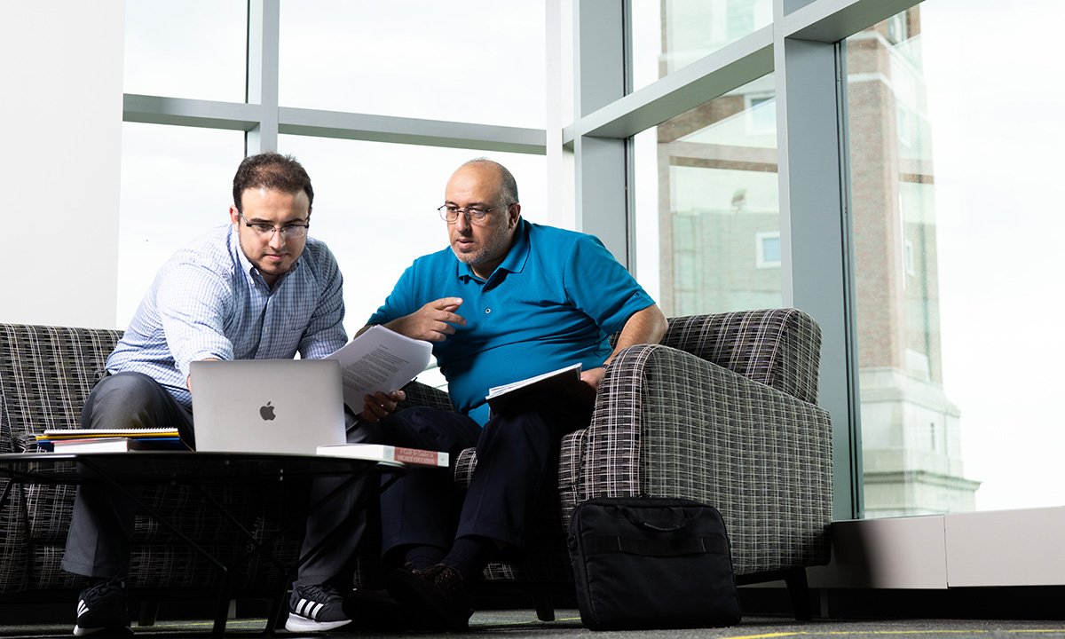 Two men sitting with a laptop