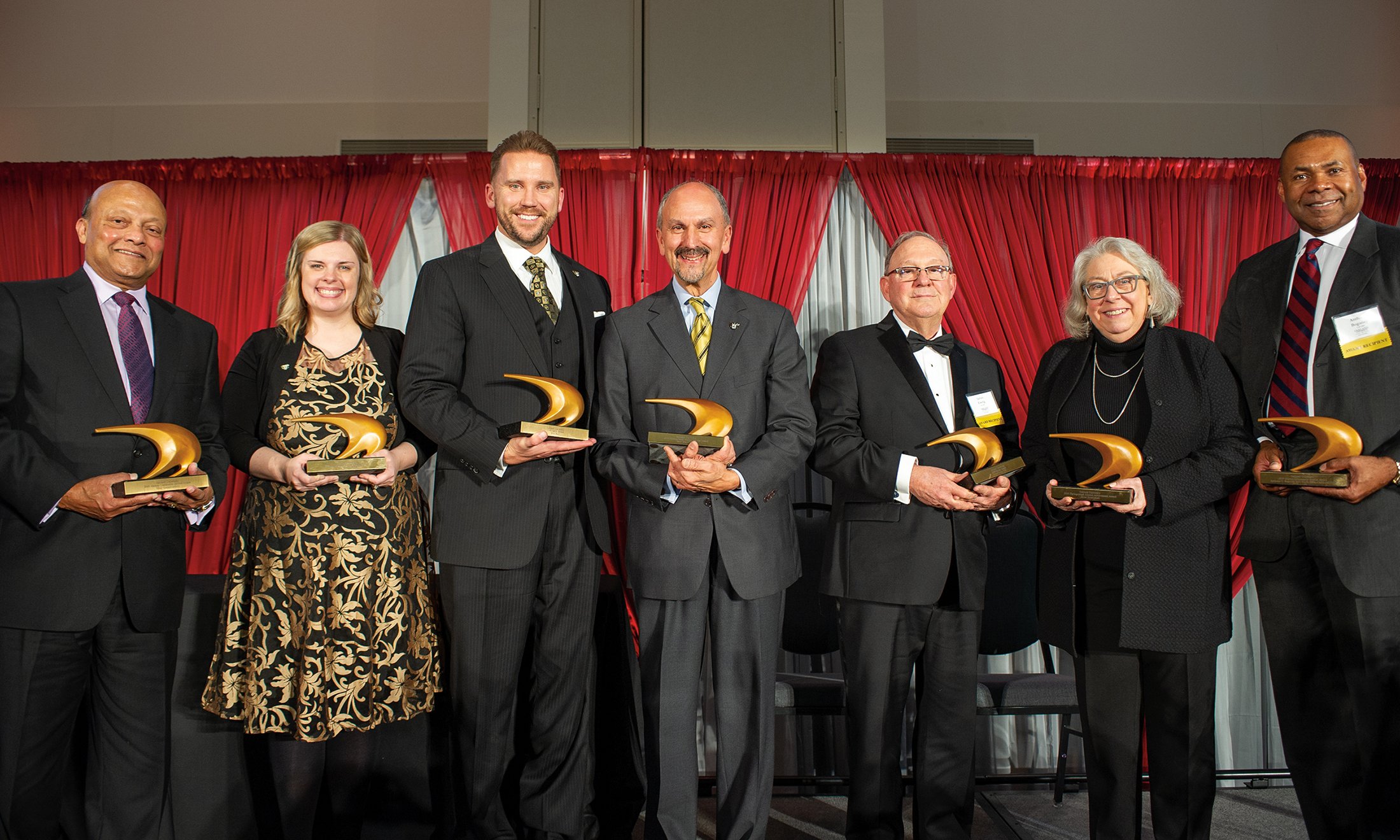 A group of people holding awards