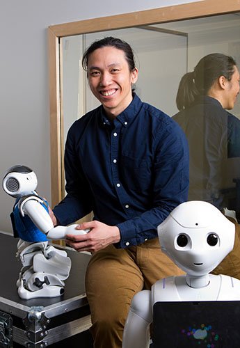 Man sitting on desk with robots