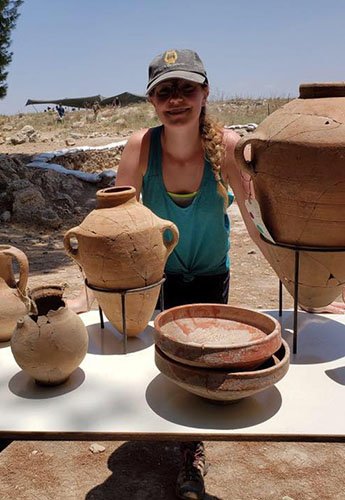 Female student standing with pottery