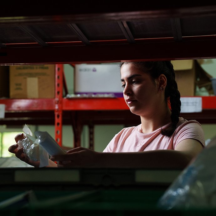 Woman looking through bins of medical equipment