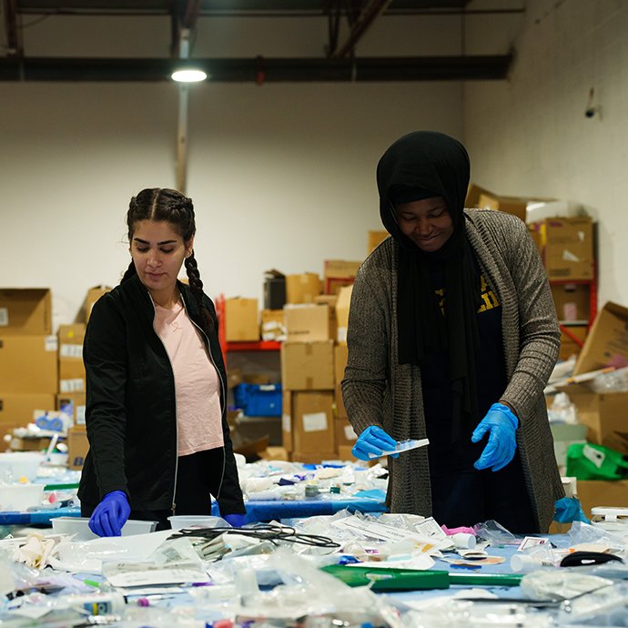 Two women sorting through medical equipment