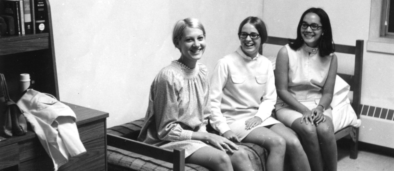 Black and white photo of three women sitting in dorm