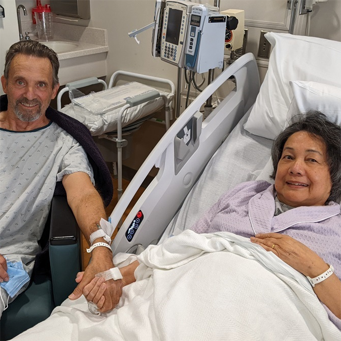 Two people in hospital holding hands