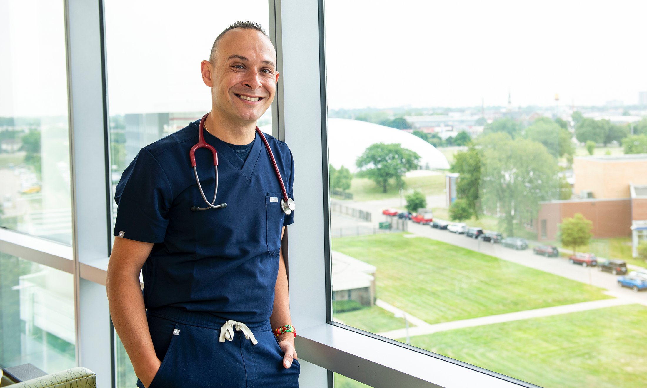 A person in scrubs next to a window