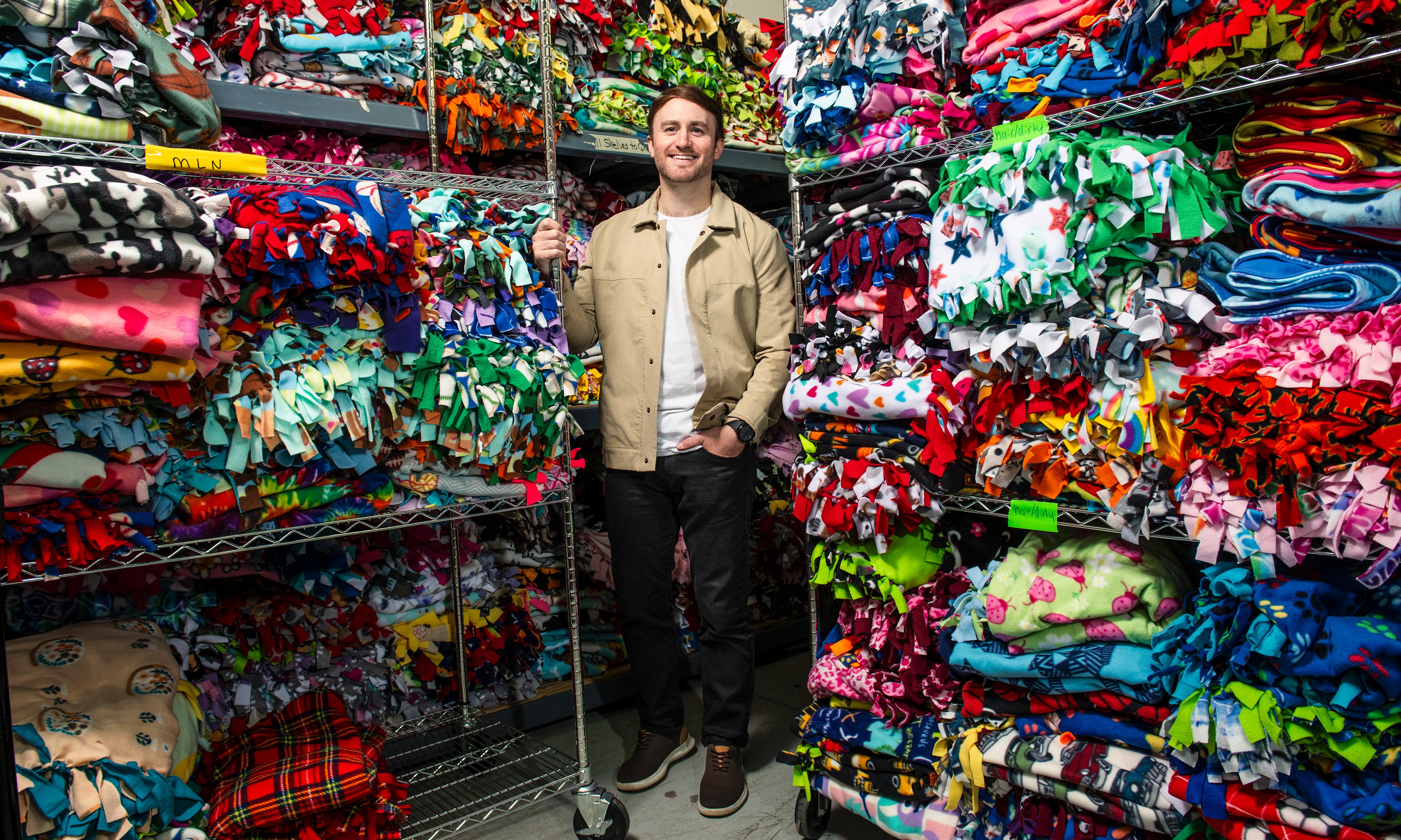 A person standing in front of shelves of blankets