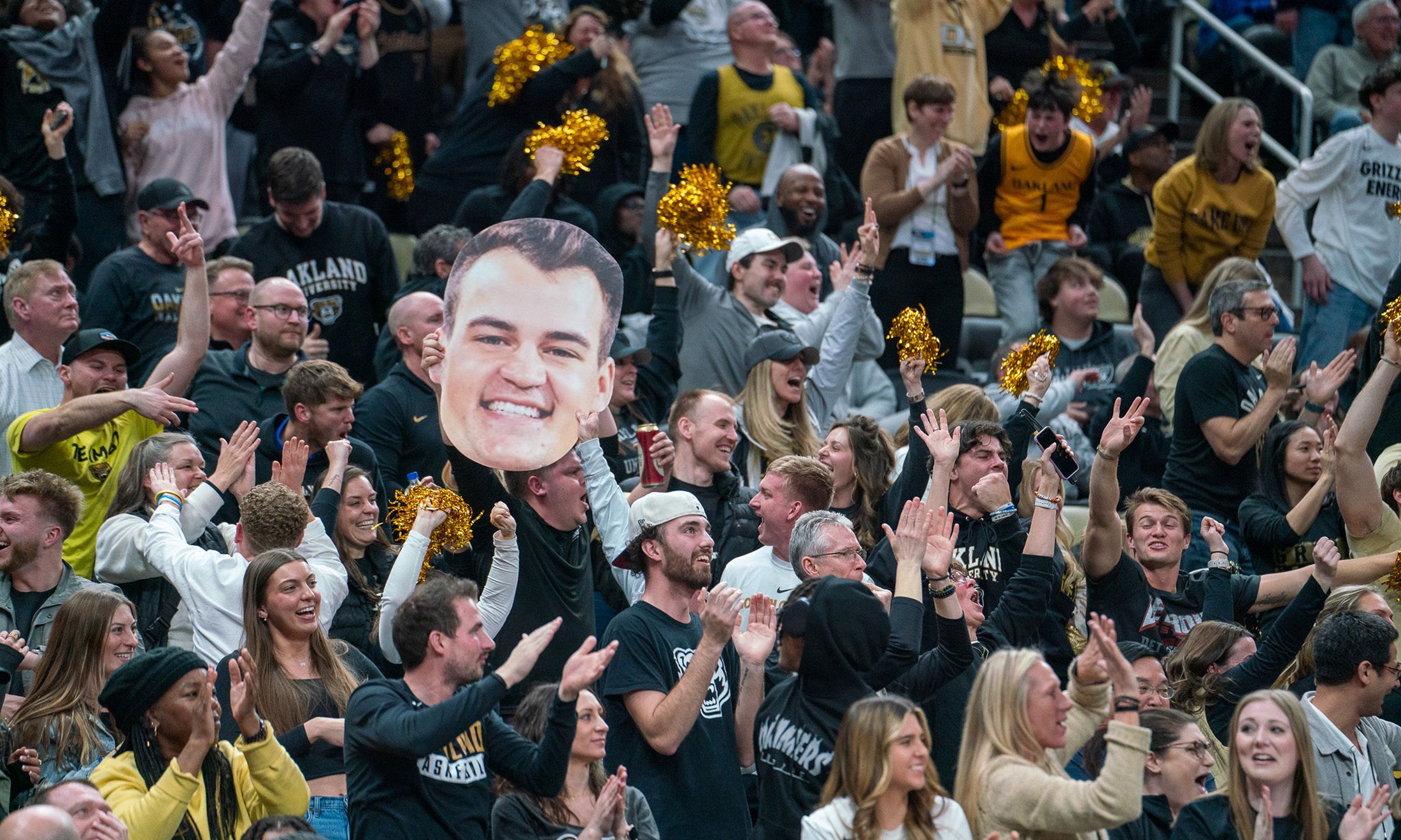 A crowd holding a cardboard cutout of Jack Gohlke's face