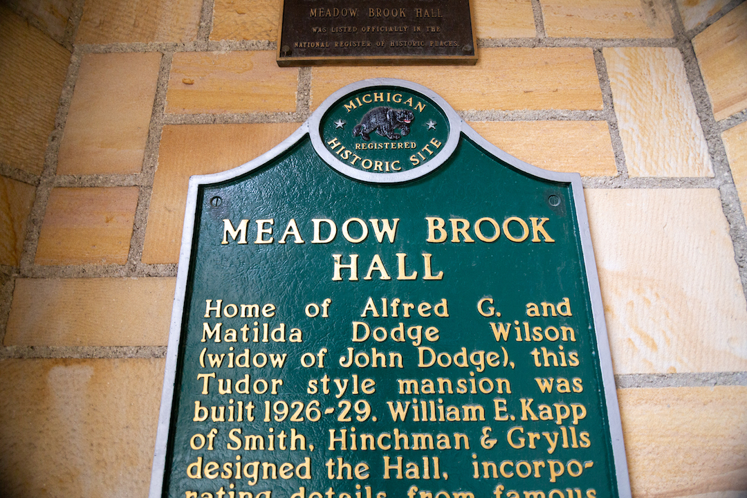 a historic sign at meadow brook hall explaining it's history