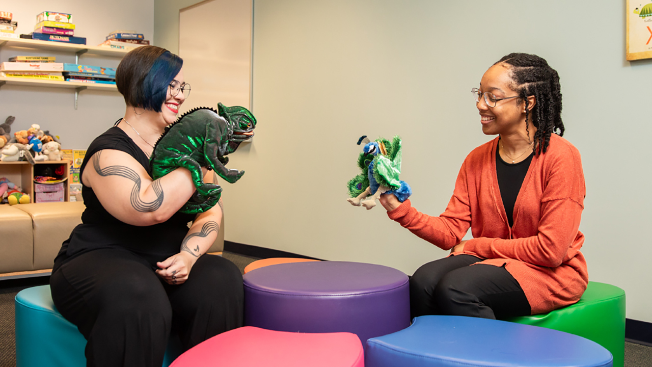 Two women demonstrating play therapy