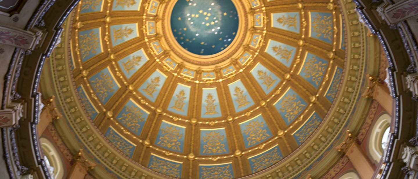 A photo looking up at an ornate blue and gold dome ceiling.