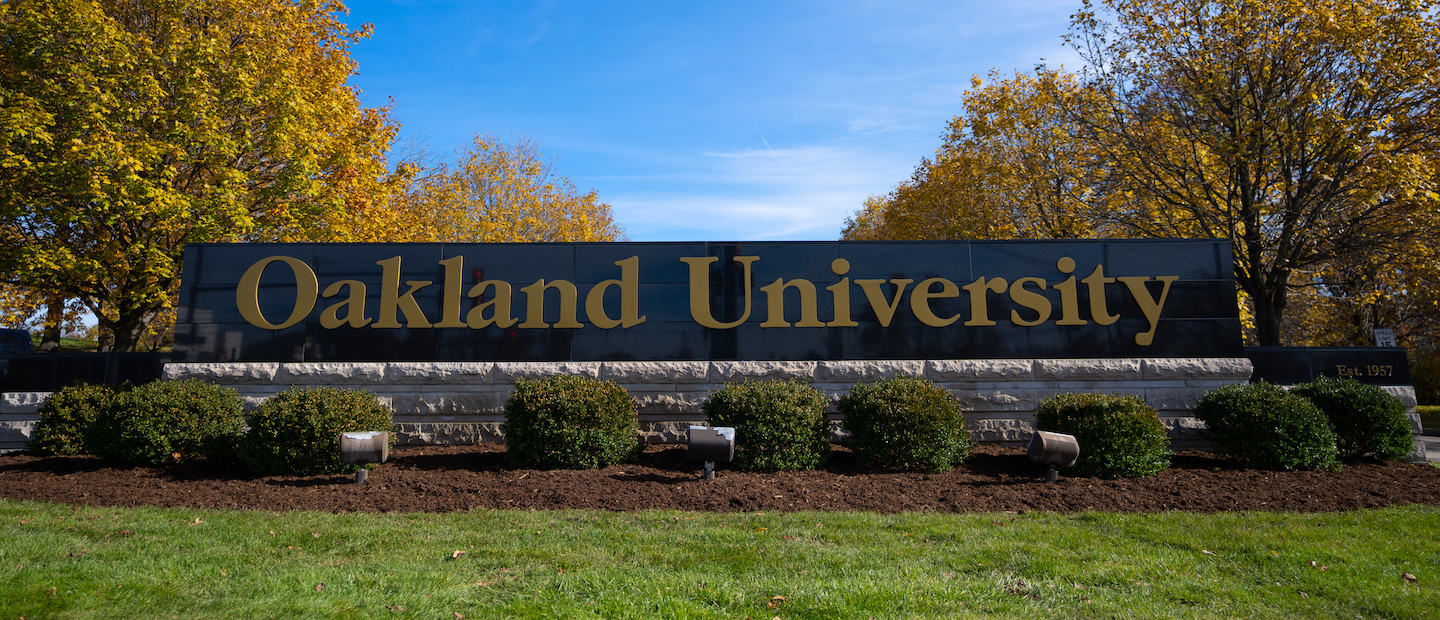 A sign that reads "Oakland University" at the entrance to campus.