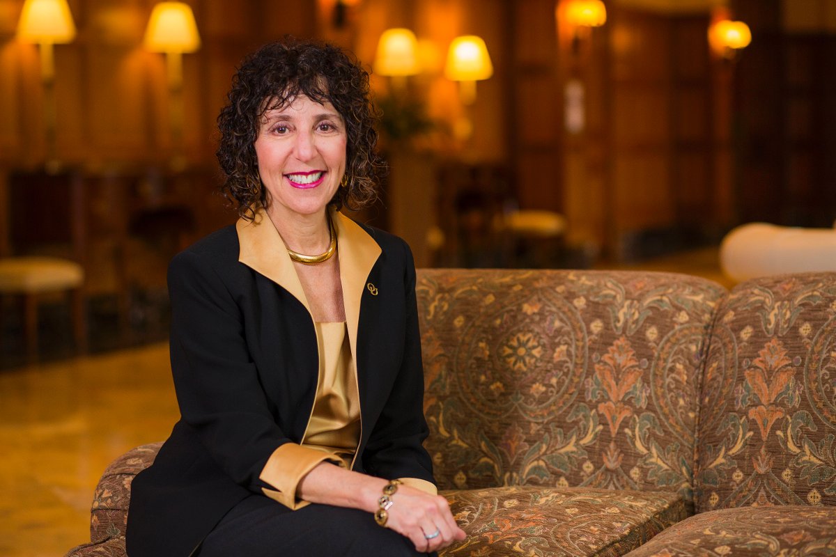 President Ora Hirsch Pecovitz Sitting on a couch smiling at the camera