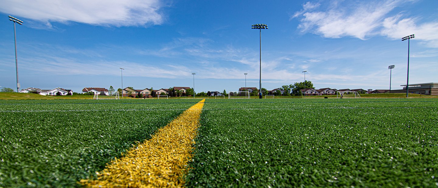 A yellow line painted on a green field at the Outdoor Complex.
