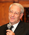 Rabbi Joseph Klein, holding a microphone.