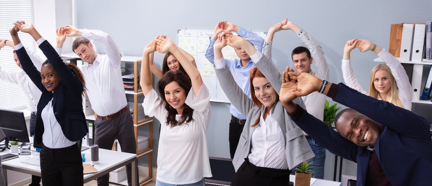Staff in a corporate office performing a side bend stretch.