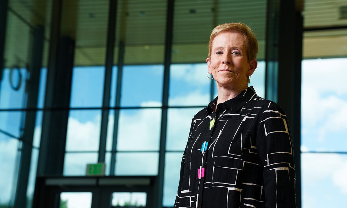 Andrea Harral stands in front of a building on the O U campus.