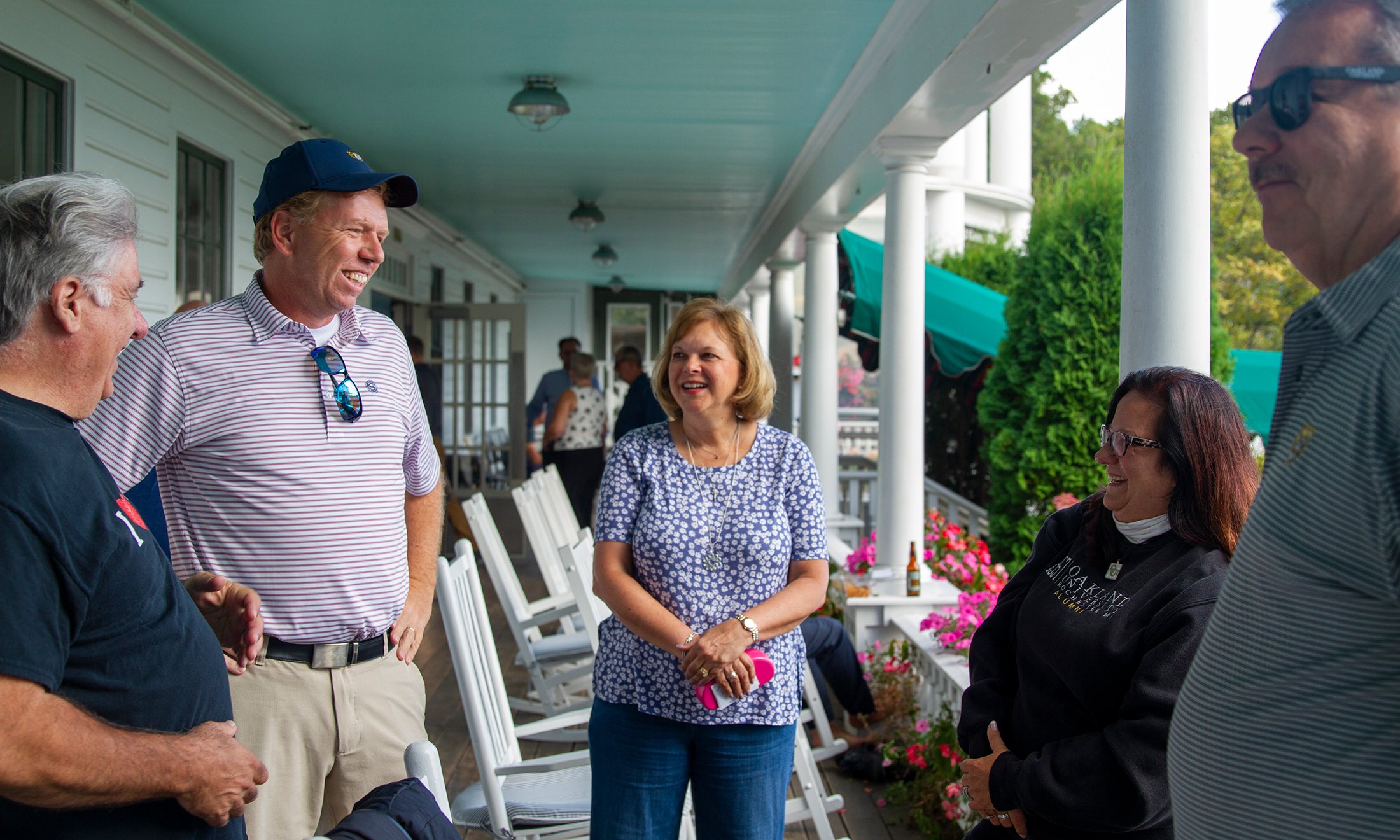 People talking on a covered balcony